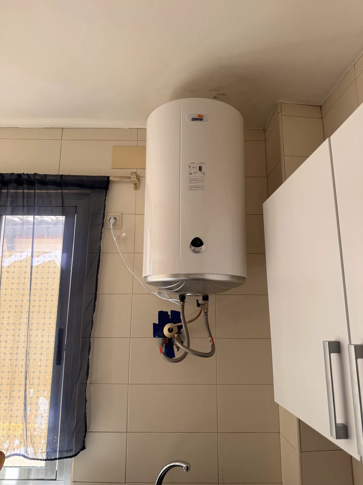Termo eléctrico instalado junto a una ventana