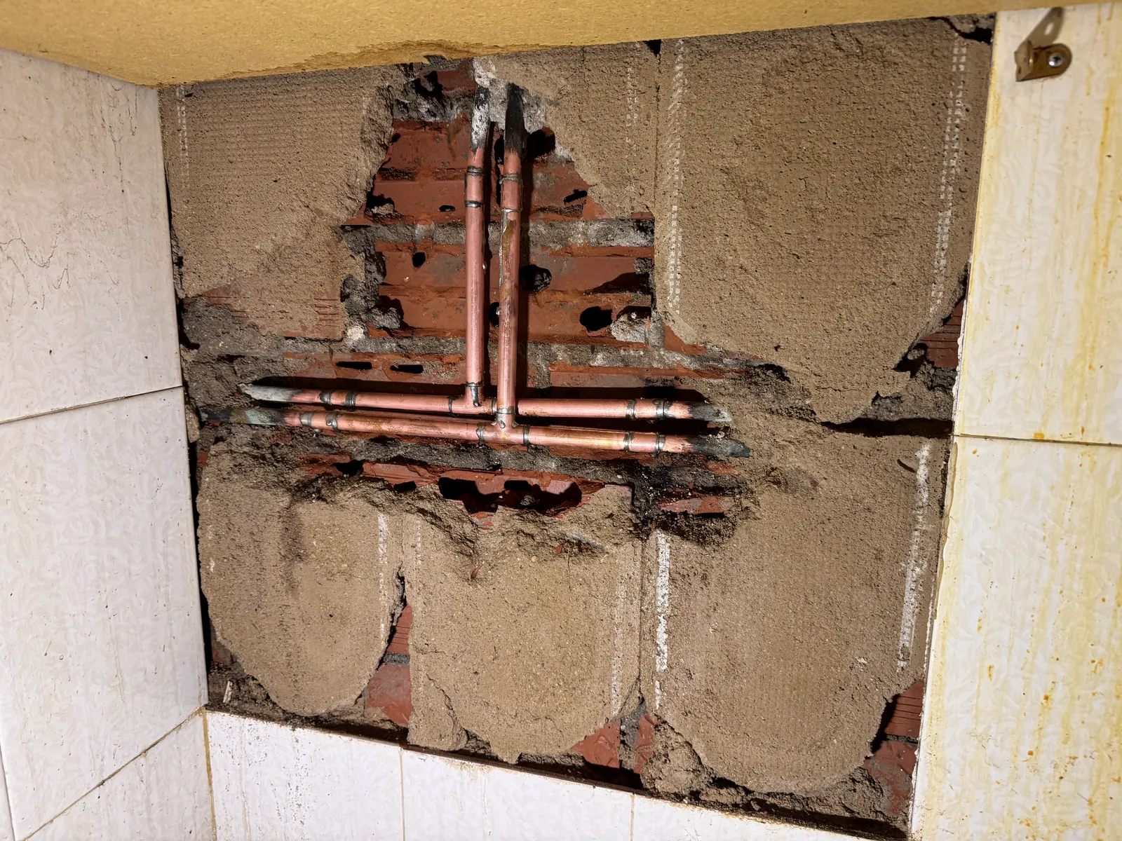 Tubería de cobre con llave de paso localizada al abrir una pared