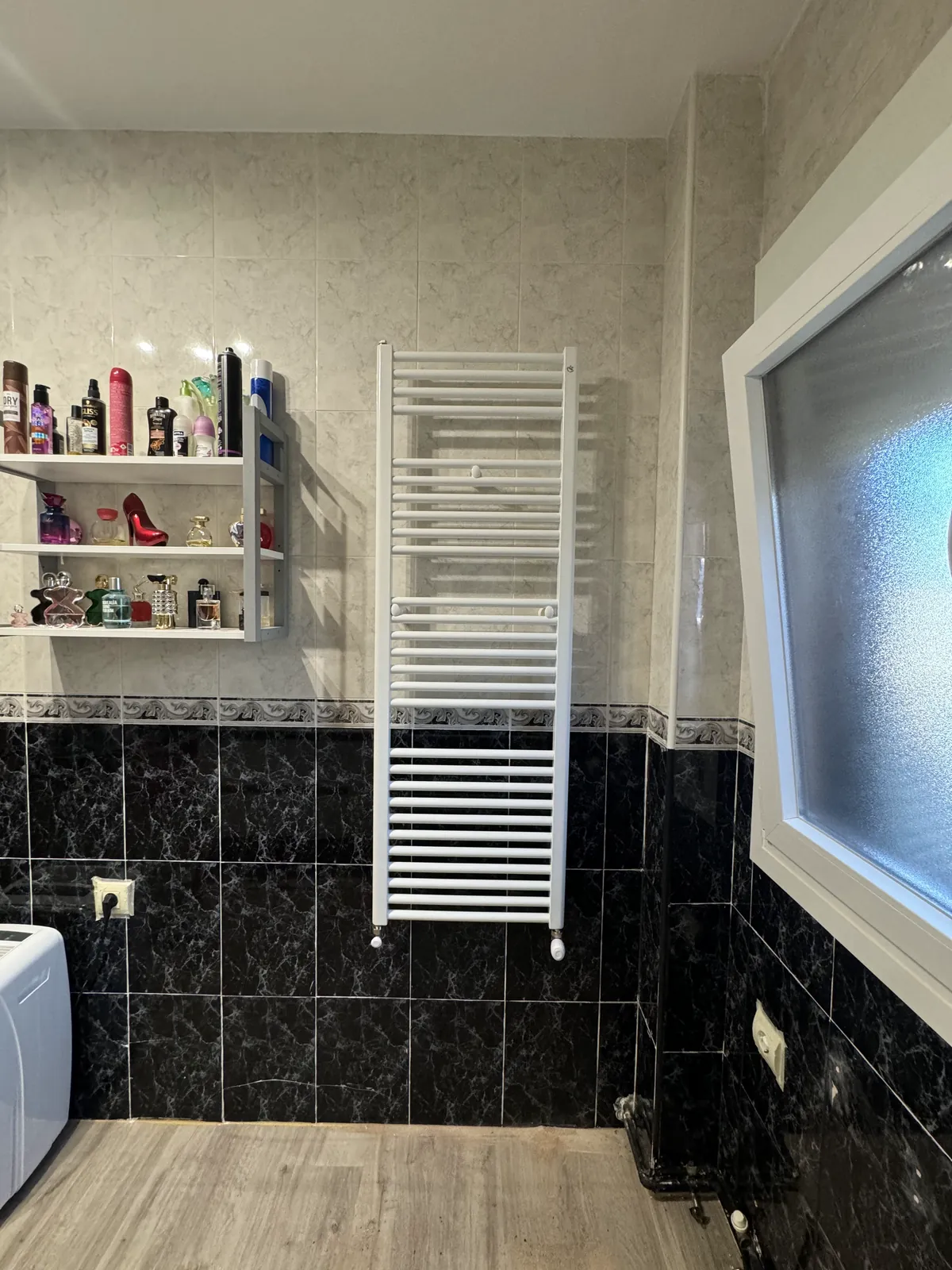 Baño con radiador toallero instalado antes de su reforma