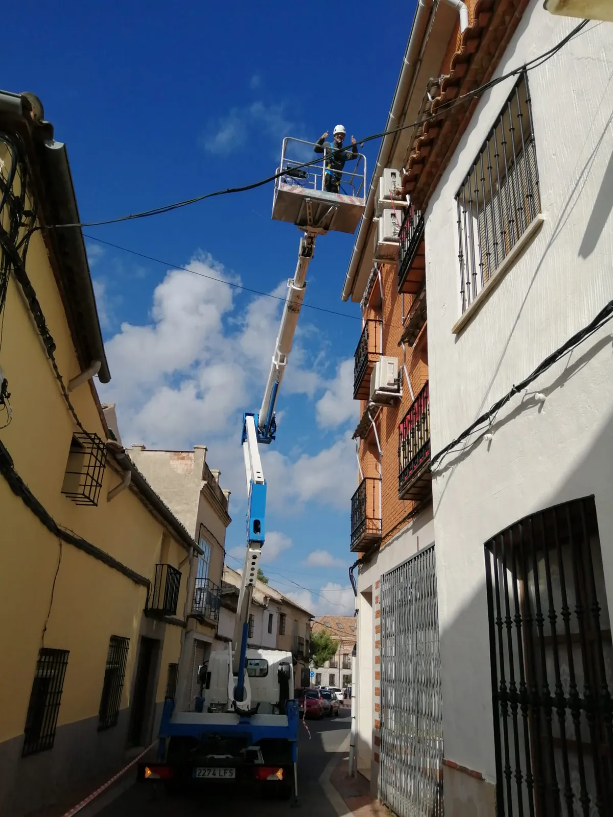 Instalación de aire acondicionado en altura con plataforma elevadora en una calle de Toledo