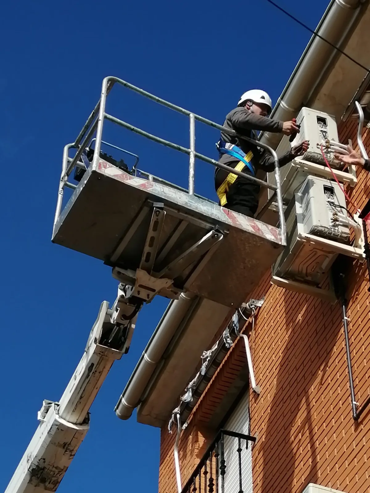 Instalación de unidades exteriores de aire acondicionado en fachada con plataforma elevadora