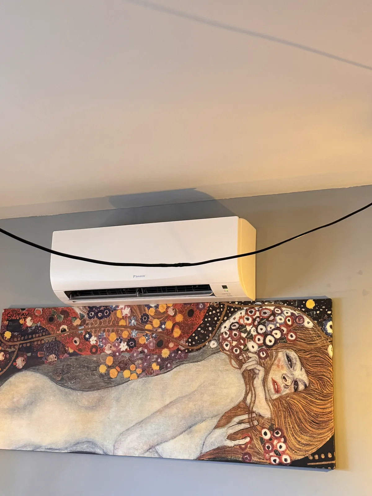 Aire acondicionado split instalado sobre un cuadro en el salón