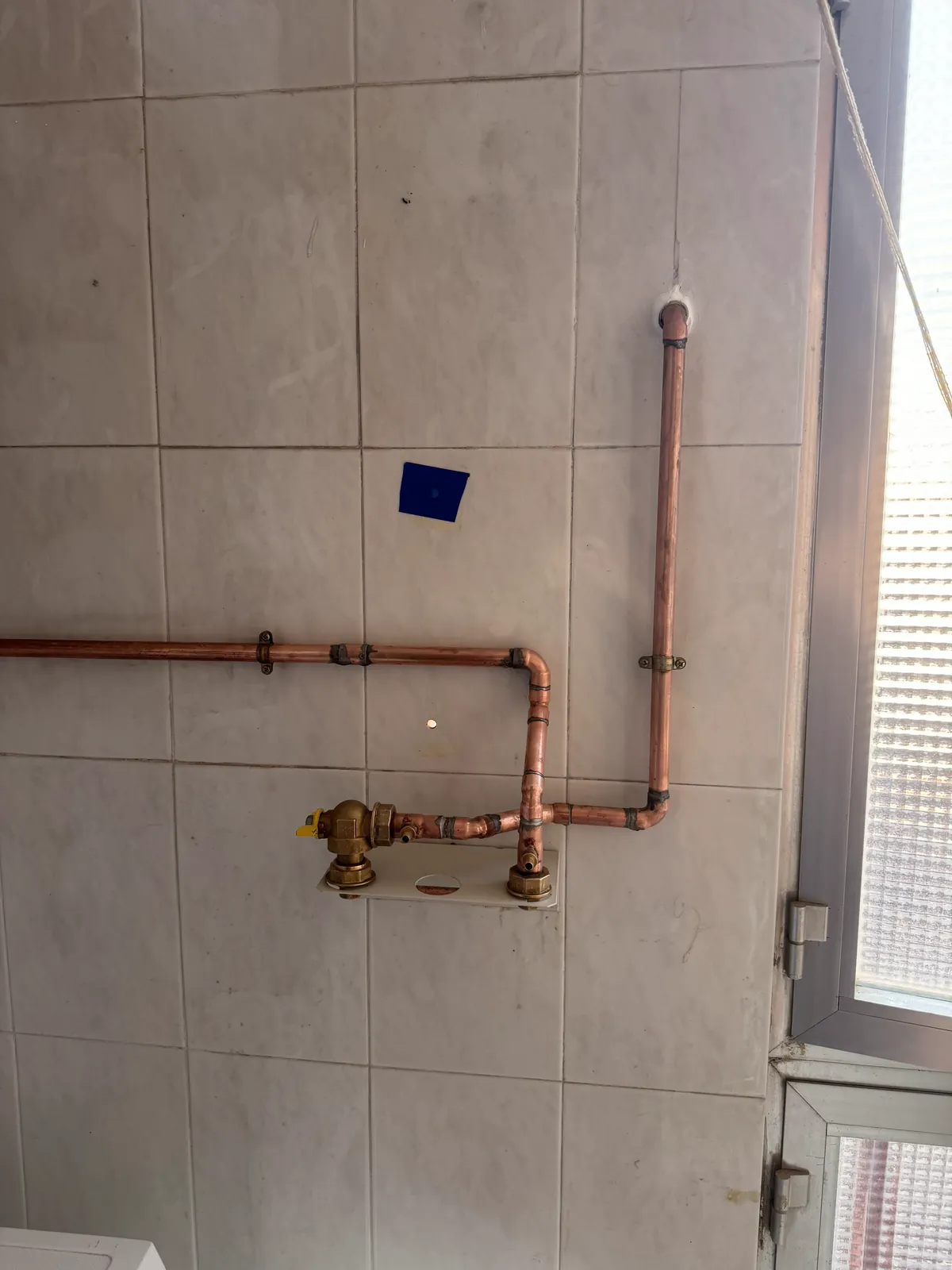 Tubería de cobre de gas con llave de corte instalada en una terraza