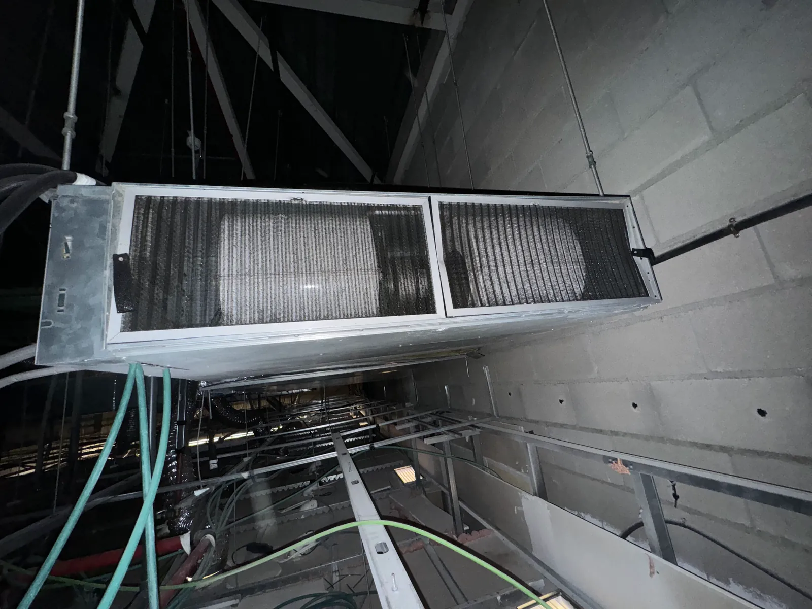 Unidad de climatización en falso techo con el filtro retirado para su limpieza