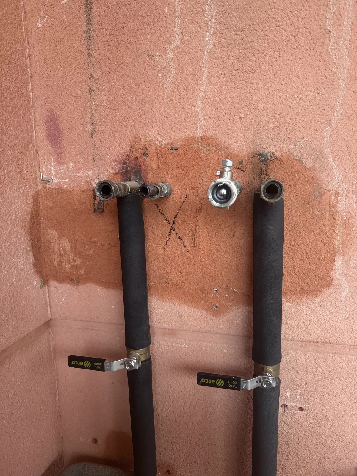 Tuberías de calefacción aisladas con llaves de corte en la pared