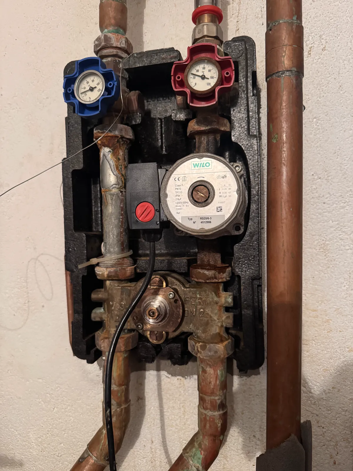 Grupo de impulsión con circulador y termómetros en una sala de calderas